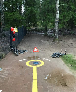 Polkupyöriä, kypäriä ja laatoitukselle maalattu radan osa.